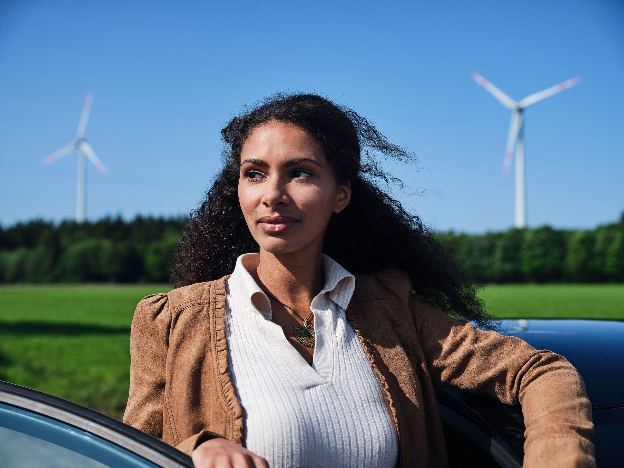 Frau steht vor Windrädern